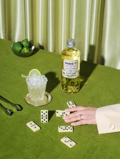 a table topped with dices and drinks next to a bottle of ginzetto