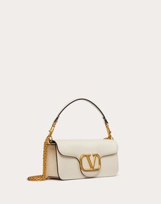 Valentino Garavani Locò shoulder bag in calfskin with metallic VLogo Signature detail. The bag can be worn on the shoulder/crossbody or carried by hand thanks to the detachable handle and the detachable sliding chain. - Antique-finish Brass hardware - Magnetic closure - Detachable leather handle - Shoulder strap with detachable sliding chain - Nappa lining. Interior: one flat pocket - Drop length: min 26 cm - max 50 cm - Dimensions: W27xH13xD6 cm - Weight: 0.5 kg - Made in Italy Light Ivory, Valentino Women, Valentino Bags, Bag Light, Christmas Bags, Branded Handbags, Luxury Accessories, New Handbags, Bago