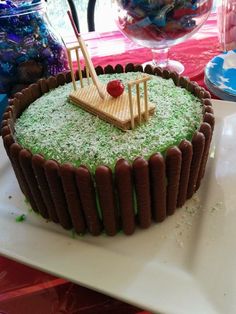 a cake that is on a plate with green frosting and grass in the middle