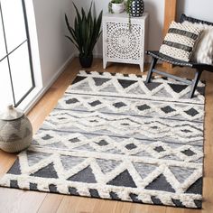 a living room area with a chair, rug and potted plant