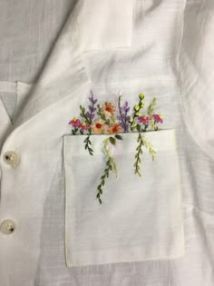 a white shirt with flowers embroidered on it