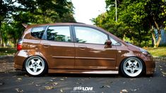 a small brown car parked on the street