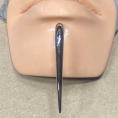 a pair of scissors sticking out of the side of a mannequin's head