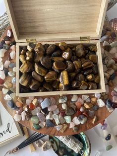 a wooden box filled with lots of rocks on top of a table next to other items