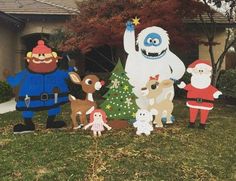 christmas yard decorations in front of a house with santa clause and rudolph the red nosed reindeer