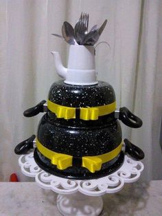 a three tiered cake with black and yellow decorations