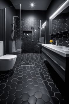 a black and white bathroom with hexagonal tiles