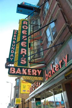 there are many signs on the side of this building that say bakery and donut shop