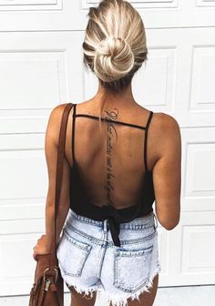 the back of a woman's body with tattoos on her upper and lower back