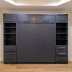 a large bookcase with two doors and three drawers in the middle of a room