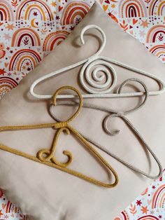 three different types of rope hangers on top of a pillow with an orange and white background