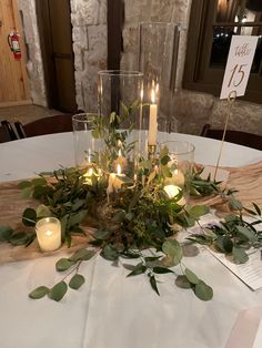 a table with candles and greenery on it