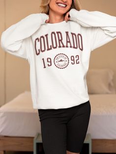 Retro Rockies: 90s Style Colorado Sweatshirt 🌲 Embrace the 90s with a Cozy Colorado Twist Transport yourself to the heart of the Rockies with our 90s Style Colorado Sweatshirt. This pullover is the perfect nod to vintage vibes, combining the rugged, adventurous spirit of Colorado with the bold, colorful designs of the 90s. Whether you're exploring the great outdoors or strolling through town, this Sweatshirt lets you wear your love for the Centennial State with retro flair. Available in 8 Awesome Colors Express your unique style with our selection of 8 vibrant colors! Whether you're a fan of muted earth tones or bold, eye-catching hues, there's a color for everyone. Inspired by Colorado's stunning natural landscapes--from alpine sunsets to crisp mountain mornings--these colors will keep y 90s Oversized Tops For College, 90s Style White T-shirt For Winter, 90s White T-shirt For Winter, Graphic Print Tops For Sports Season On Campus, White Winter Tops For Campus, Oversized White Sweatshirt For Campus, 90s Style Tops With Ribbed Cuffs For College, White 90s Sweatshirt For Fall, 90s White Sweatshirt With Letter Print