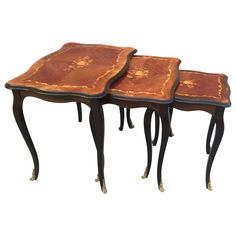 two tables with wooden tops and gold leaf designs on them, one is made out of wood