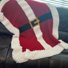 a knitted santa hat on top of a black leather couch