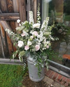 a metal bucket filled with white and pink flowers