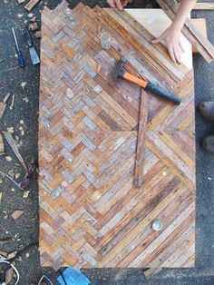 a person is working on some wood planks with a hammer and screwdriver