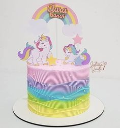 there is a rainbow cake with two unicorns on it and the name clavy cakes