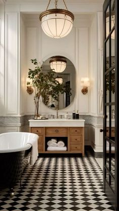 a bathroom with a checkered floor and black and white tile on the floor, along with a claw foot tub