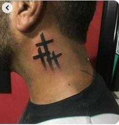 a man with a tattoo on his neck has a cross tattooed on the back of his neck