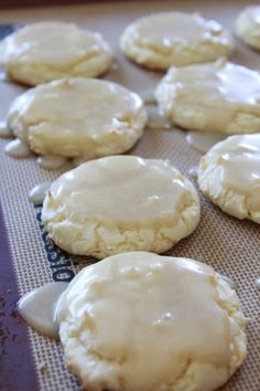 cookies with white icing sitting on a baking sheet