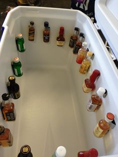 a bathtub filled with lots of bottles and condiments next to each other