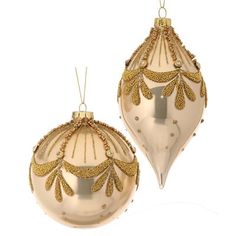 two gold christmas ornaments hanging from strings