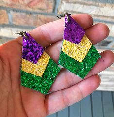 "Metallic Purple, Yellow & Green Glitter Mardi Gras Triple Stacked Earrings! This is a true purple the first pic was in sunlight! Handmade. 2 1/4\" x 1.5\" Lightweight & Super Stylish." Purple Glitter Party Jewelry, Stacked Earrings, Glitter Earrings, Jan 17, Green Glitter, Pink Leopard, Leather Earrings, Mardi Gras, One Pic