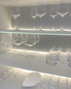 many wine glasses are lined up on a shelf