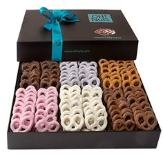 an open box filled with assorted pretzels next to a ribbon tied around it