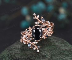 a black diamond ring sitting on top of a rock