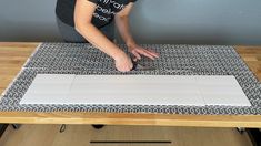 a woman is cutting paper on top of a table