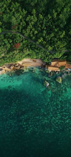 an aerial view of the ocean and beach from above, with boats in the water