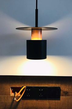 a lamp that is on top of a wooden shelf next to a remote control box