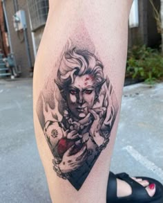 a woman's leg with a tattoo on it and an image of a demon