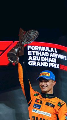 a man in an orange uniform holding up a trophy