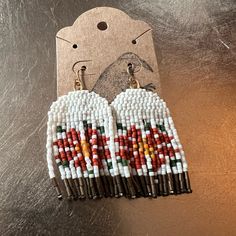 a pair of beaded earrings with white and red beads on top of each other