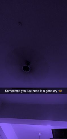 a purple light that is on the ceiling in a room with a quote above it