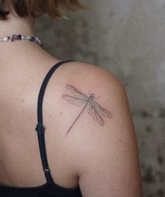 a woman with a dragonfly tattoo on her shoulder