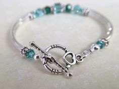 This bracelet has been uniquely created by combining emerald and light turquoise crystals together. Such a pretty combination! Perfect for your upcoming wedding to gift to your bridesmaids, mother of bride/groom, Jr bridesmaids, etc. OR, a great birthday, anniversary or just because gift. Choose from a toggle or lobster claw clasp from the dropdown menu at checkout. ~ 6mm and 4mm emerald and lt turquoise swarovski crystals ~ sterling silver bead caps ~ silver plated curbed tube bead bangles and Sterling Silver Bracelets For May Birthstone Anniversary, Adjustable Turquoise Jewelry For May Birthstone, Nickel-free Crystal Bangle Bracelet For Gift, Adjustable Birthstone Beaded Bracelets For Anniversary, Silver Bracelet For Anniversary With May Birthstone, Turquoise Birthstone Bracelet, Silver Charm Bracelet For May Birthstone Gift, Silver Bracelets For Birthday With May Birthstone, Silver Beaded Bracelets With Birthstone For Wedding