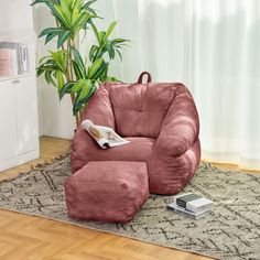 a living room with a pink bean bag chair and footstool in front of a potted plant