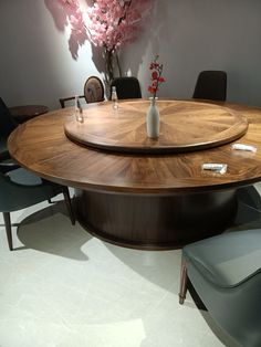 a wooden table with chairs around it and a vase on the table in front of it