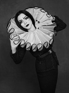 a black and white photo of a woman with a fan on her head