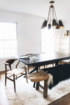 a dining room table with two chairs and a bench