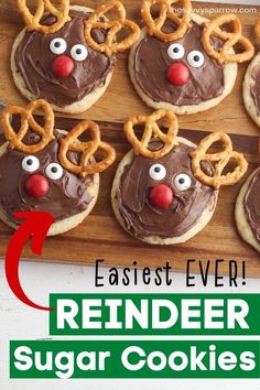 reindeer sugar cookies with chocolate frosting and pretzels on top, sitting on a cutting board