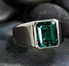 "A classic, bold, heavy ring with a bezel set Lab Grown Emerald. It is the epitome of an understated, ultra elegant, impressive Emerald Ring! The Lab Grown Emerlad is 9mm x 11mm, weighng at 5 carats. This is a ring to wear for all occasions! We are all in love with its simplicity and great style. Who we are: We are a team lead by Eden, our designer and jeweler, whose picture you see, is the talent, and the driving force of our group. We have been making custom jewelry since 1975. At our workshop Smaragd Ring, Team Lead, Ring Bezel, Driving Force, Emerald Ring, Bezel Setting, Custom Jewelry, Lab Grown, Eden