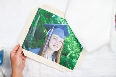 a person holding up a polaroid with a graduation cap and gown on top of it