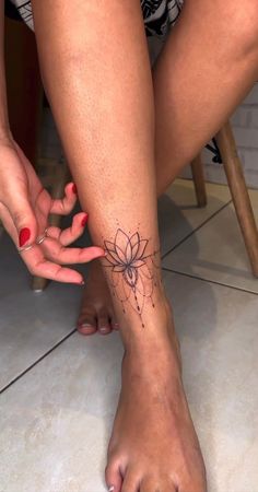 a woman's foot with a flower tattoo on it