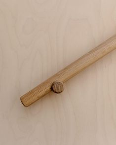 a close up of a wooden handle on a wall with wood grained surface in the background