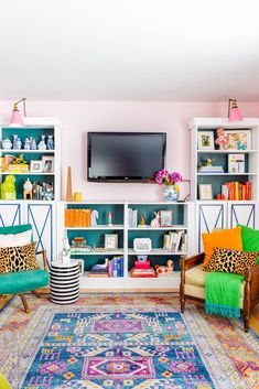 the living room is decorated in bright colors and has colorful rugs on the floor